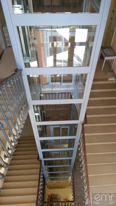 Pylône vitré dans la cage d'escalier existante